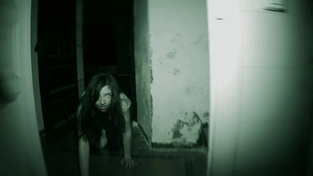 Eerie image of girl crawling in dim, spooky corridor